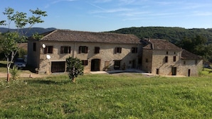 A stone building with a tiled roof, multiple windows, and a small garden area in front. - Domaine du Colombier- A Southern France Living Experience (Larroque)