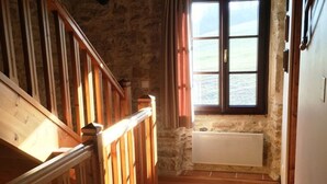 A narrow hallway with wooden flooring, stone walls, and a window with a view. - Domaine du Colombier- A Southern France Living Experience (Larroque)