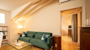 A modern living room with a green sofa, a glass coffee table, and a wooden cabinet. - San Jacopo Top by Mmega (Florence)