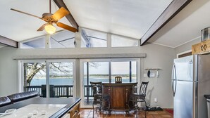 Una cocina con una isla grande, un ventilador de techo y vistas a través de puertas de cristal.
