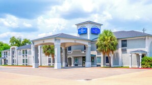 A Fairway Inn with a two-story structure, covered parking area, and palm trees. - Fairway Inn (La Porte)