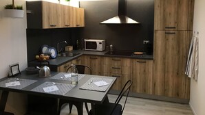 A compact kitchen with wooden cabinets, a microwave, and a kettle on the counter. - SCIESA 24 APARTMENTS - CIR 023091-LOC-02700 - CIN IT023091C28NS3TMSQ (Verona)