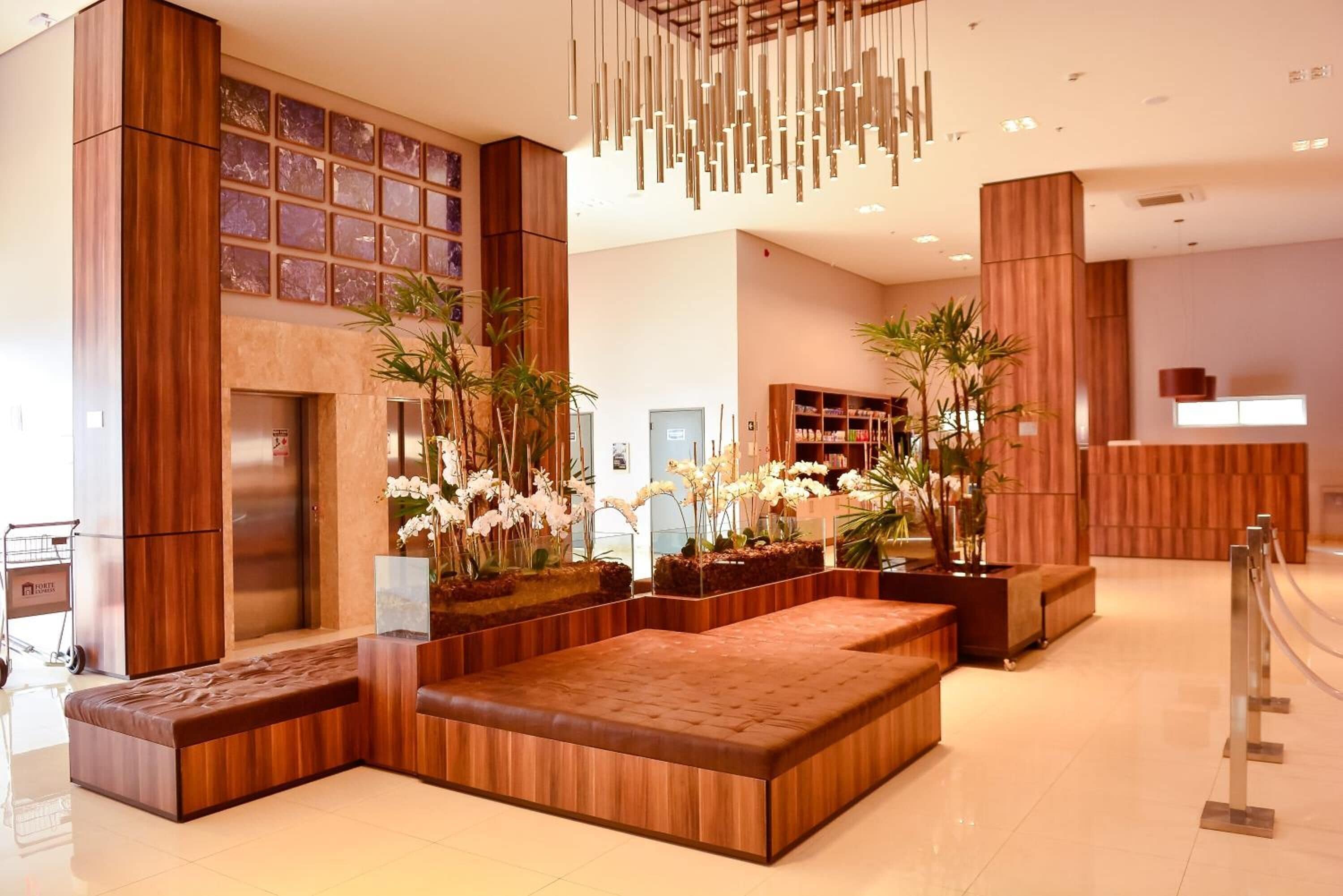 A modern lobby with wooden paneling, a seating area, and a reception desk.