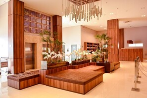 A modern lobby with wooden paneling, a seating area, and a reception desk. - Forte Express (Macapa)