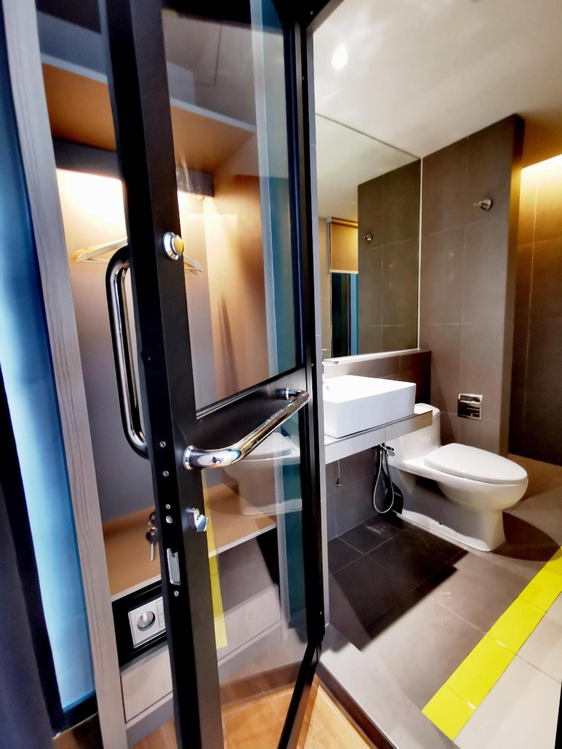A modern bathroom with a glass shower enclosure, a white sink, and a toilet.