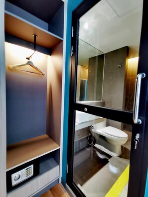 Une salle de bain moderne avec une paroi en verre, des toilettes et un rideau de douche suspendu.