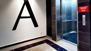 A modern elevator with a digital display, a large illuminated letter 'A' on the wall, and a sign indicating the level 'G'. - Sovotel Conezion Putrajaya (Serdang)