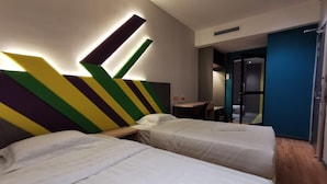 A hotel room with two beds, a desk, and a bathroom visible through an open door. - Sovotel Conezion Putrajaya (Serdang)