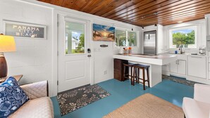 Una cocina con techo de madera, encimera blanca y vista al exterior.