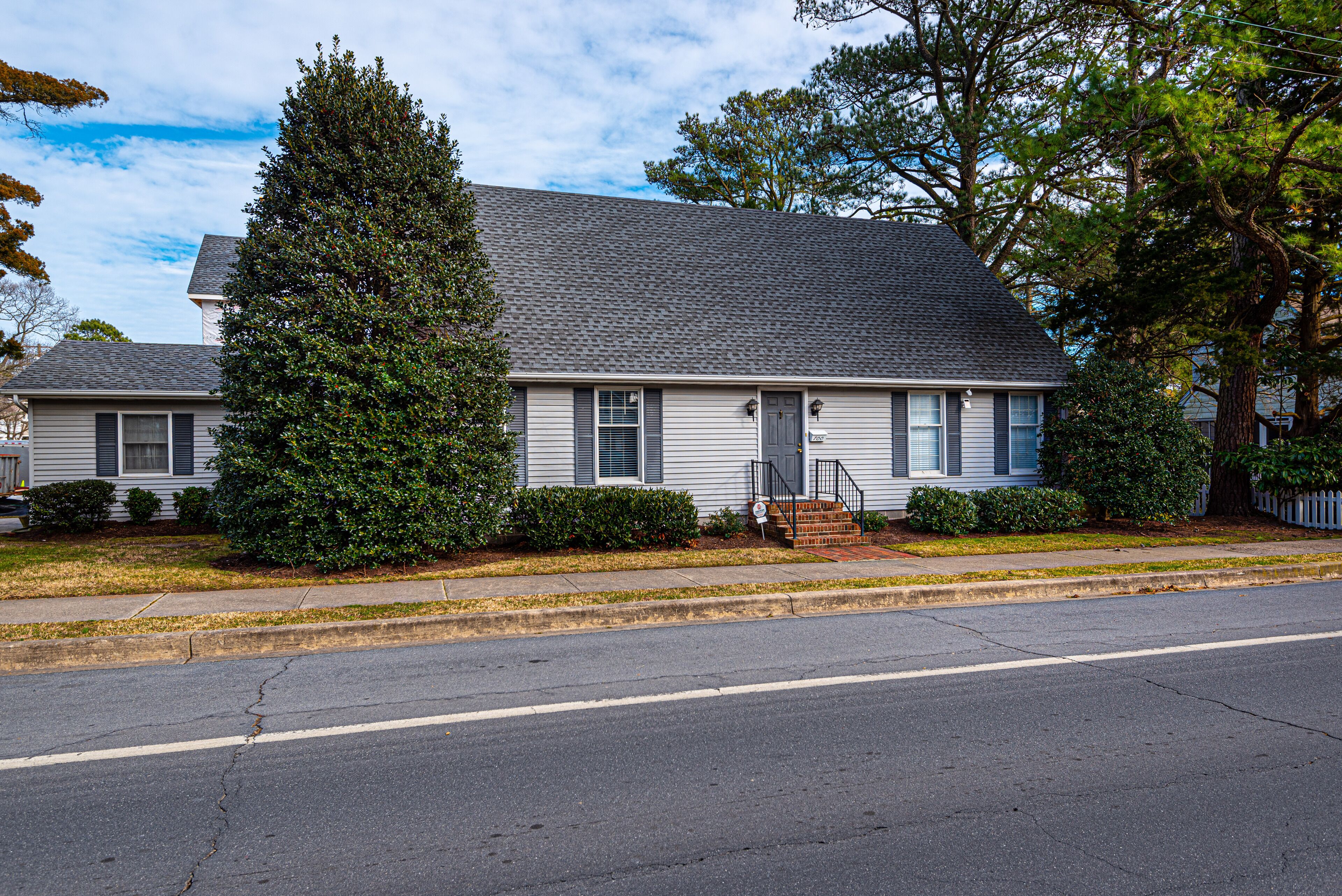 A two-story house with a grey roof, white siding, and a front porch.