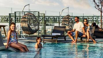 Relax by the pool with a clear view of the surroundings, surrounded by lounge chairs and a hanging chair.