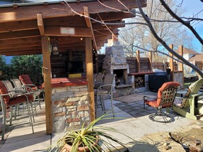 An outdoor patio with stone walls, a fire pit, and outdoor seating. - Enjoy this amazing home and yard as you eat, pray and fall in love with NE Mpls. (Minneapolis)