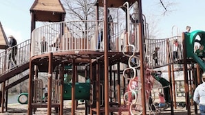 Une aire de jeux dotée de nombreuses structures ludiques, notamment un toboggan en spirale et des éléments d’escalade.