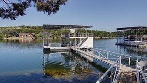 A dock with a covered seating area and a staircase leading into the water. - Welcome to Gemstone at Possum Kingdom Lake (Graford)