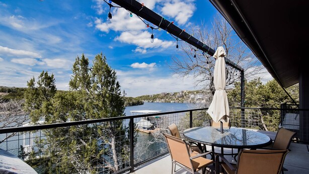 A balcony with a round table and chairs, overlooking a lake and trees. - Welcome to Gemstone at Possum Kingdom Lake (Graford)