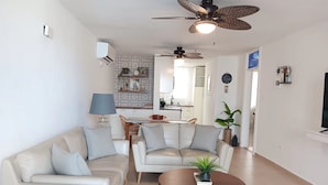 A living room with a sofa, armchairs, a coffee table, and a ceiling fan. - Cozy 2 Bdrms Condo Apt Few Steps from the Beach (Río Grande)