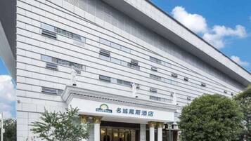 A modern hotel with a flat facade, large windows, and a prominent entrance with columns.
