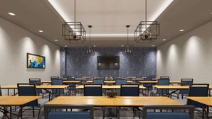 A conference room with multiple tables and chairs, a flat-screen TV, and geometric patterned walls.