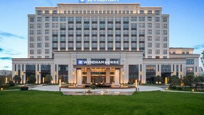 Un grande hotel moderno con un evidente cartello con la scritta 'WYNDHAM' in alto.