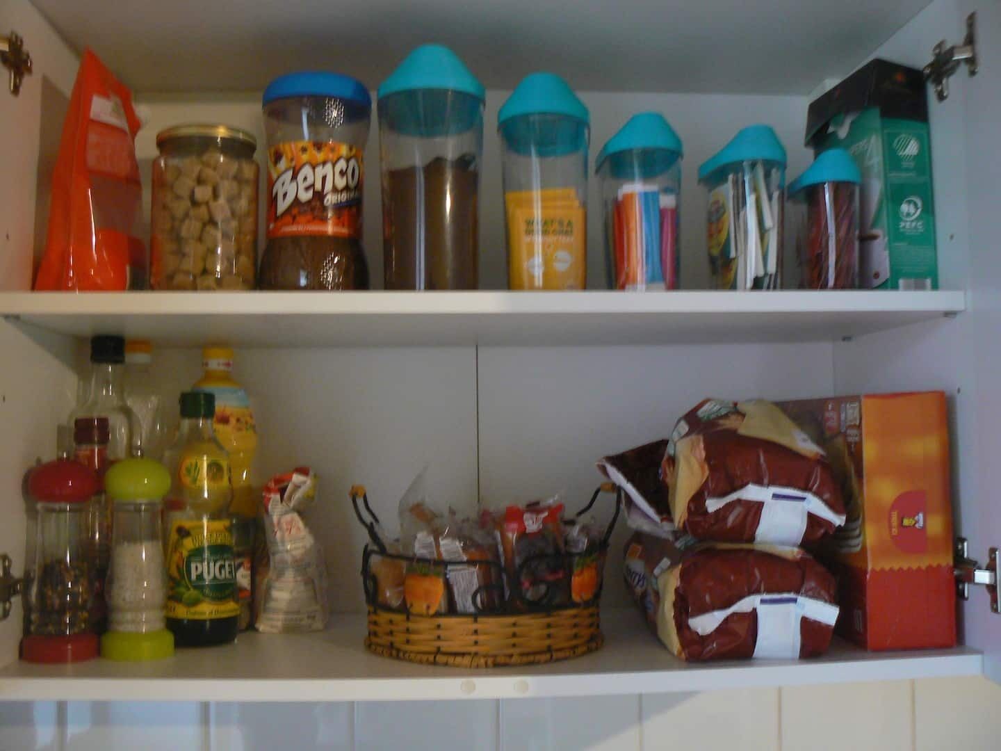 A kitchen pantry with various food items and condiments.