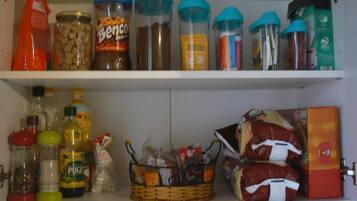 A kitchen pantry with various food items and condiments.