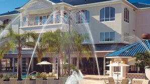 A large, multi-story house with a prominent tower, a swimming pool, and outdoor seating areas. - Three Bedroom Deluxe Condo, Orlando, Florida (2194699) (orlando)