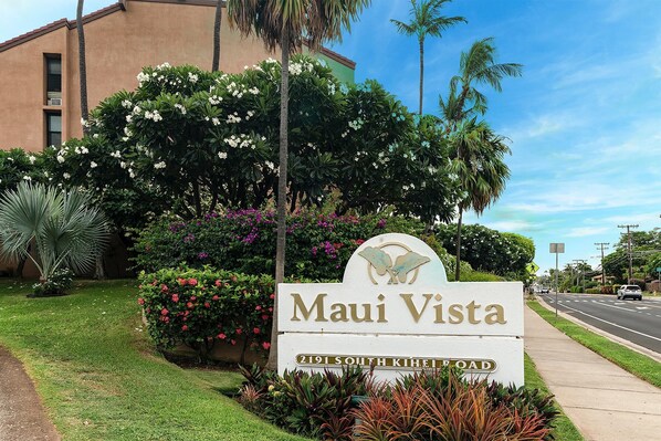 Schild für 'Maui Vista' in der South Kihei Road 2191, umgeben von üppiger Vegetation und Palmen.