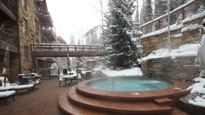 A hot tub area with a stone wall and a wooden bridge. - Timbers 3076 (Keystone)