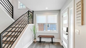 Un interior moderno con una escalera, un banco, una ventana y una cita motivacional en la pared.