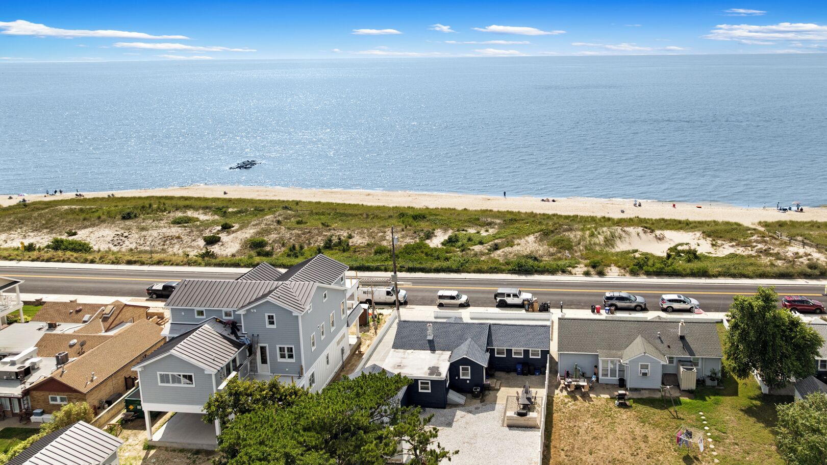 Ein Küstenwohngebiet mit Häusern, einer Straße und einem Strand.