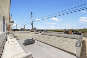 A street view with a sidewalk, a building with steps, and a clear sky.