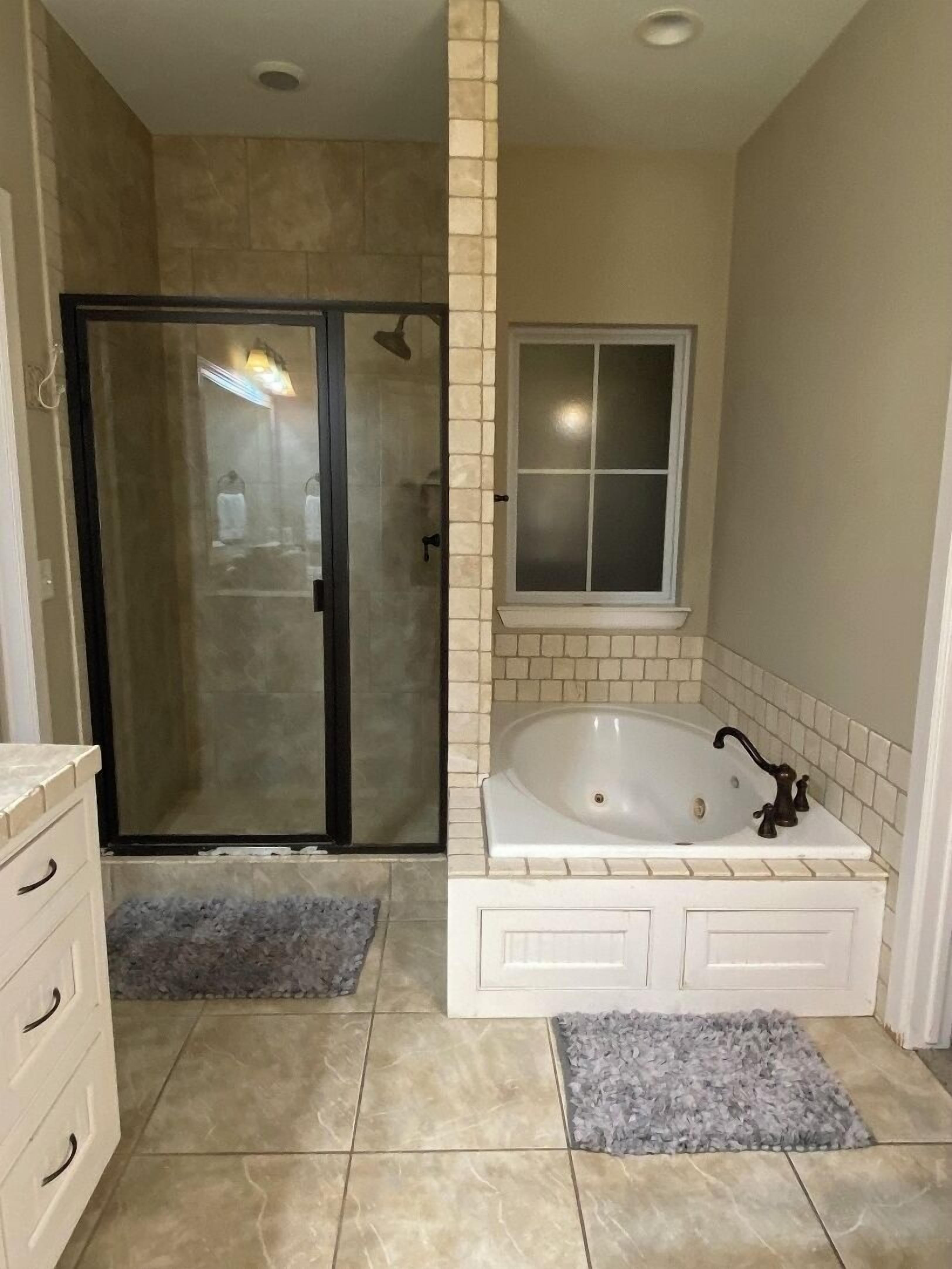 Tina con regadera, tina de hidromasaje, secadora de cabello, toallas 