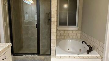 Tina con regadera, tina de hidromasaje, secadora de cabello, toallas