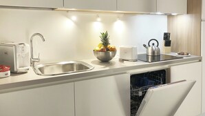 Eine moderne Küche mit einer Spüle aus Edelstahl, einer Obstschale, einem Toaster und einem Wasserkocher.