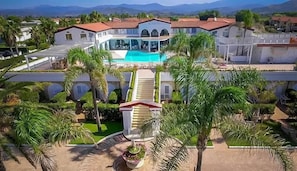 Un hotel con piscina, palmeras y vistas a las montañas.