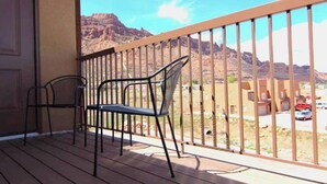 A balcony with two chairs and a view of a mountainous landscape. - Moab Oasis Entire Condo (Moab)