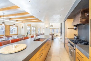 Una cocina moderna con una isla grande, horno empotrado y electrodomésticos de acero inoxidable.