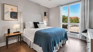 Ein modernes Hotelzimmer mit einem großen Bett, einem Schreibtisch und Blick ins Freie.