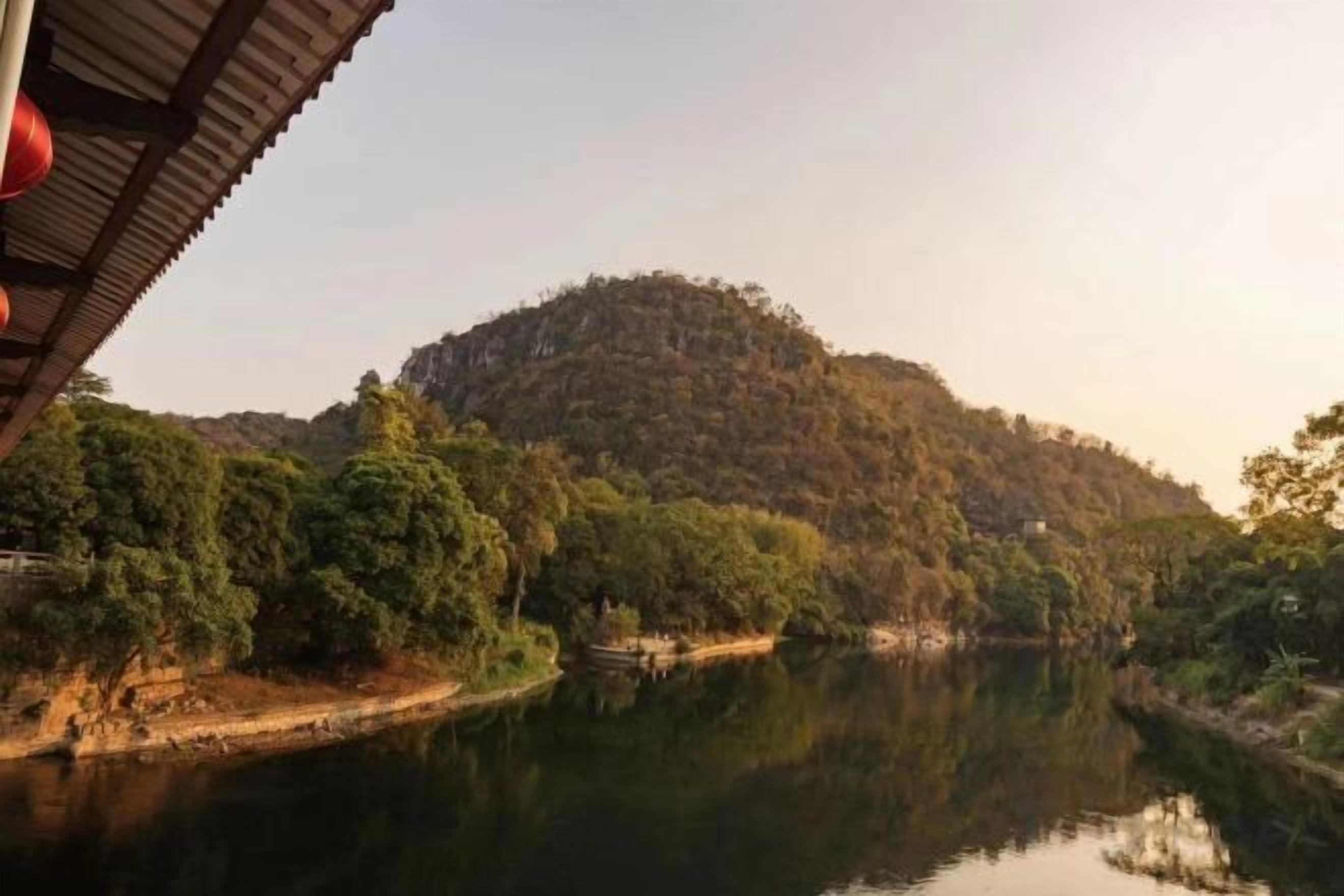 A river with a forested hill in the background.