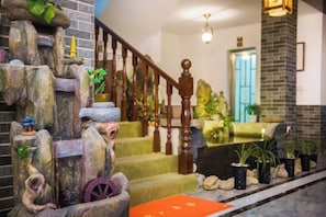 A staircase with a decorative rock wall, wooden railing, and potted plants. - Guilin Eiffel Hotel (Xiangbishan Liangjiang Sihu Branch) (Guilin)