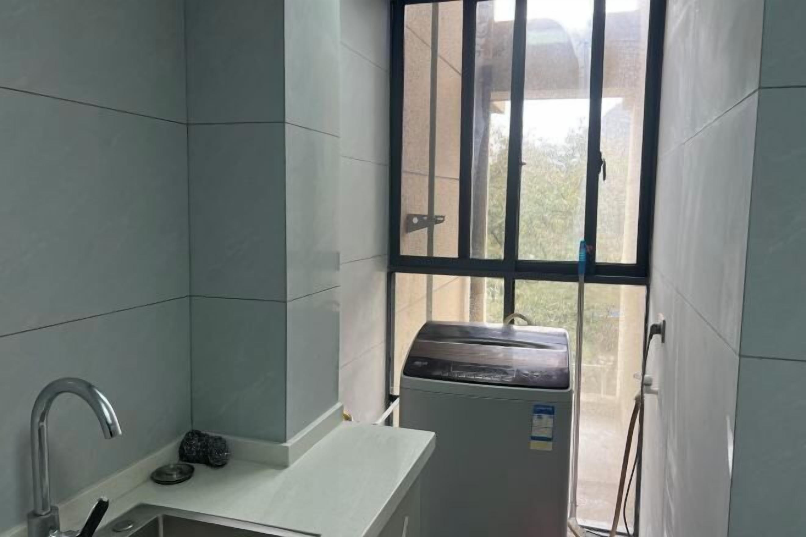 Une petite salle de bain propre, avec un lavabo blanc, un miroir et une fenêtre ornée de barreaux en métal.