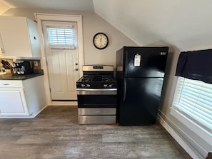 A compact kitchen with a stove, oven, and refrigerator.