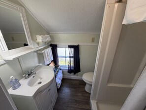 Ein kleines Badezimmer mit Waschbecken, Spiegel und Toilette.