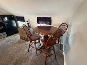 A compact kitchen with a dining area, including a round wooden table and four chairs.
