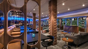 Een moderne lounge met lederen zitplaatsen, een bar en uitzicht op groen.