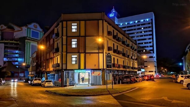 A multi-story hotel with a ground-level entrance, a visible restaurant, and a parking area. - D'green Hotel Kuching (Kuching)