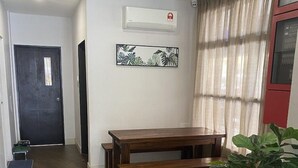 A hallway with a wooden bench, a potted plant, and a ceiling fan. - D'green Hotel Kuching (Kuching)