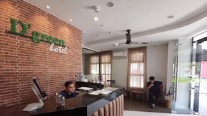 A reception desk with a digital kiosk, a brick wall with the hotel name, and a glass door entrance. - D'green Hotel Kuching (Kuching)