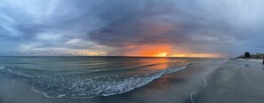 A beach with waves, a sunset, and a cloudy sky. - Beachfront condo with intracoastal views in Tampa Bay area, heated-cooled pool! (Indian Rocks Beach)