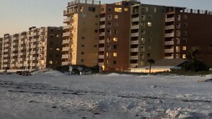 A multi-story building with balconies, a flat roof, and a sandy ground. - Beachfront condo with intracoastal views in Tampa Bay area, heated-cooled pool! (Indian Rocks Beach)